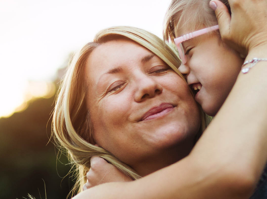 Mother lovingly hugging daughter