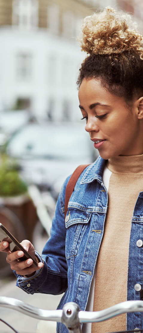 Shot of an attractive young woman using her cellphone while out cycling through the city