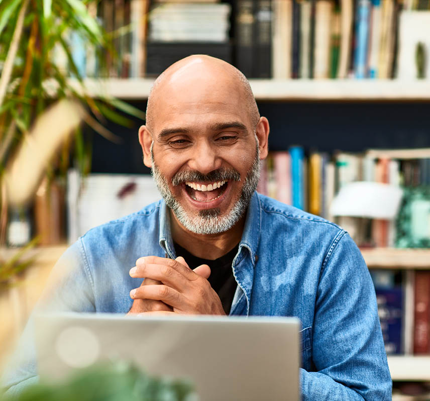 Cheerful handsome mature man at home speaking on video call using laptop, happiness, carefree, relaxation, communication