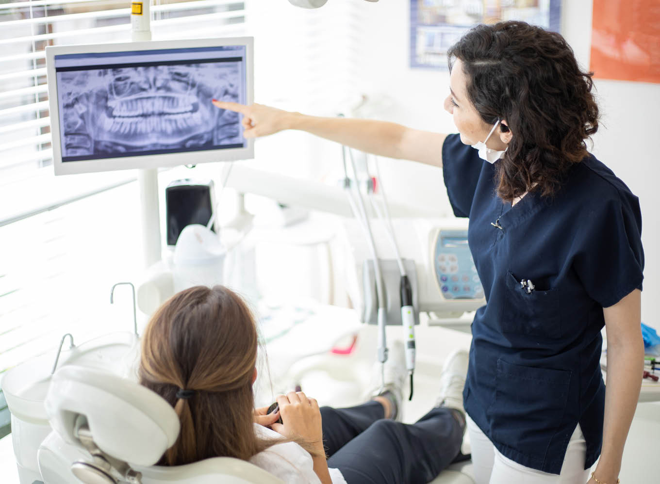 Female dentist talking to her patient at dentist's office