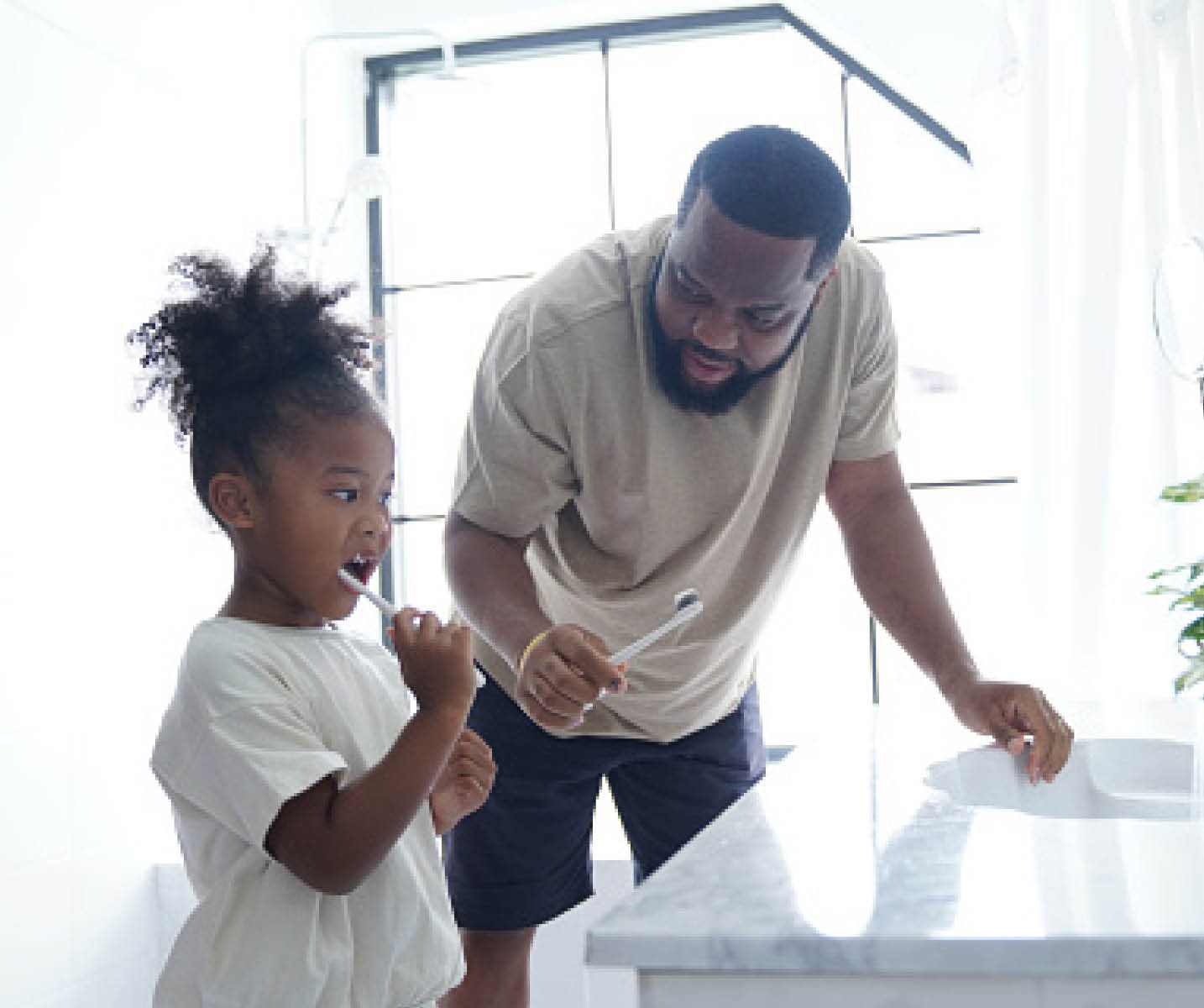 Father and daughter doing brushing in bathroom, little girl kid cheerful to preparing brushing with her father in the bathroom, backlight photography shooting