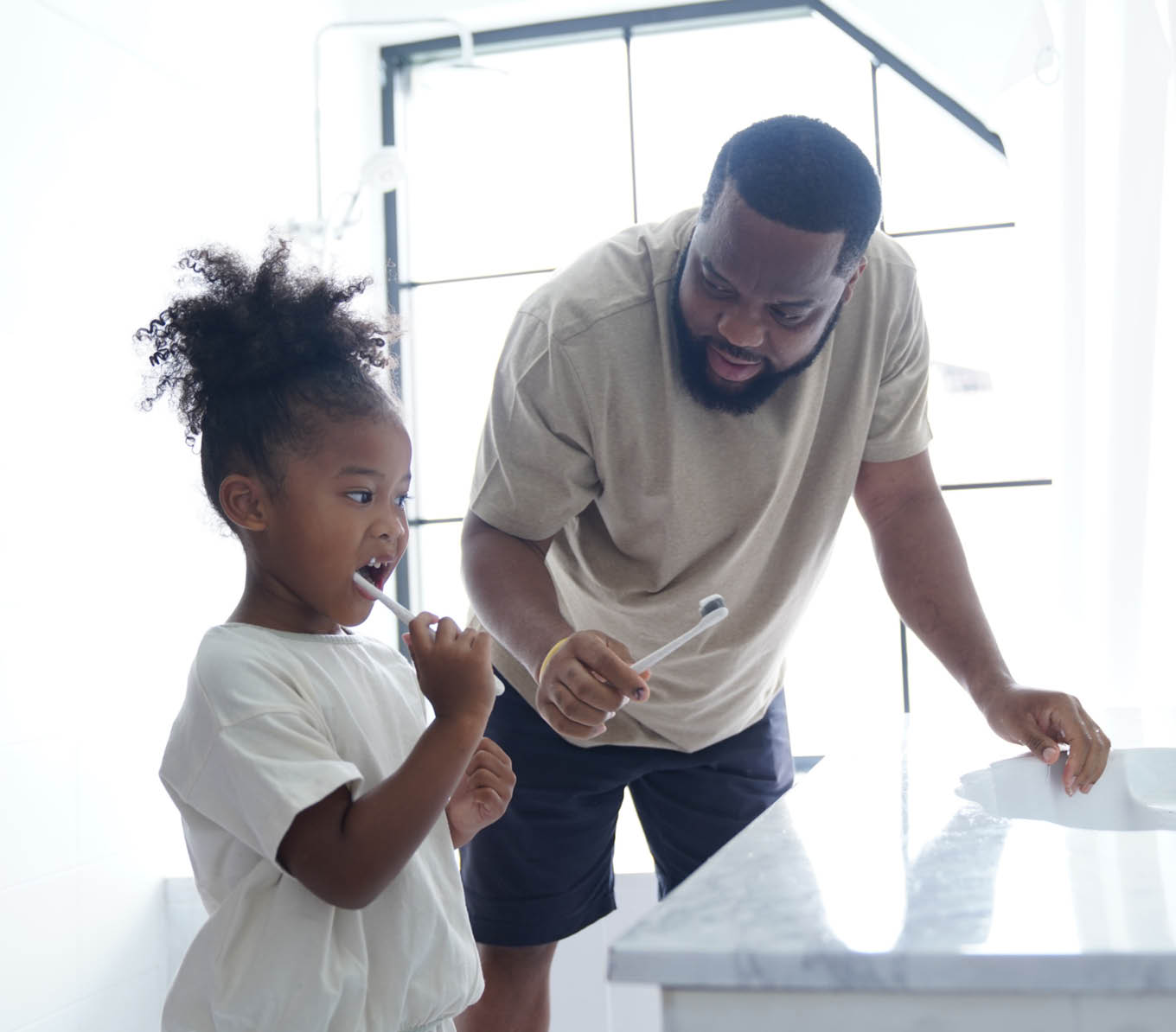 Father and daughter doing brushing in bathroom, little girl kid cheerful to preparing brushing with her father in the bathroom, backlight photography shooting