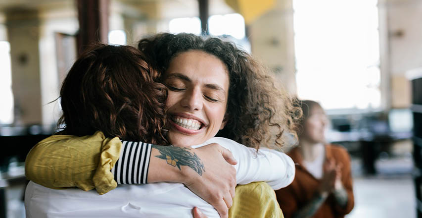 Photo of two female co-workers embracing