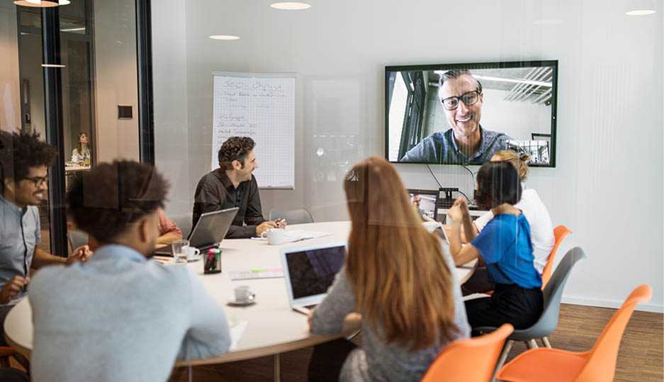 Multi-ethnic male and female professionals video conferencing in meeting room at office