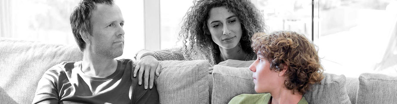 A man and woman sitting on a couch. Description generated by AI