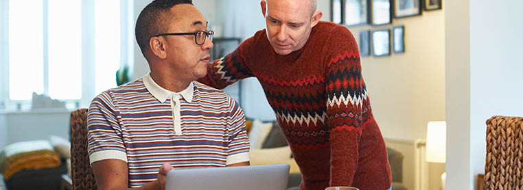 A married couple in a discussion around a laptop