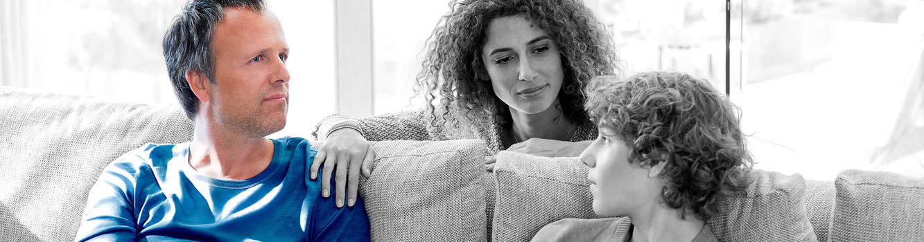 A man and a woman sitting on a couch. Description generated by AI