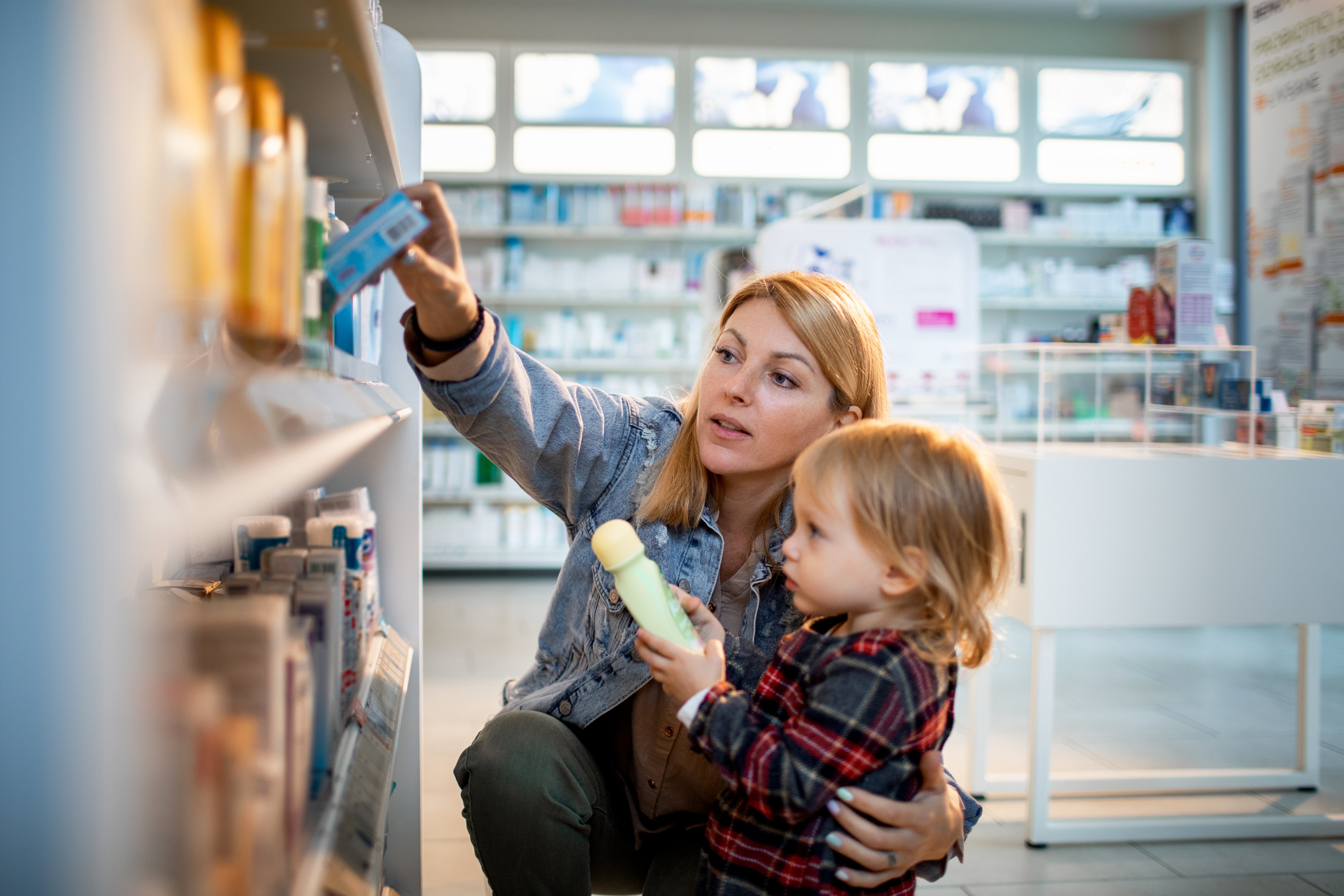 Mother and son look at medical items on a store shelf. 