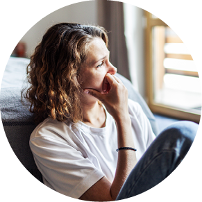 Young adult woman with depression sitting at home alone